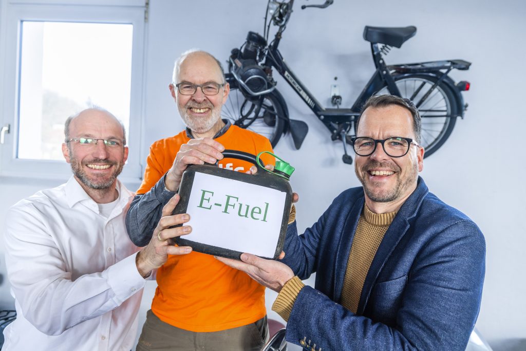 Markus Heineking, Wolfgang Driehaus (Verkehrsgruppe adfc) und Oliver Hasskamp (FDP) präsentieren den ersten Kanister mit e-Fuels für Fahrräder.